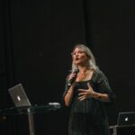 Woman with Microphone Speaking on Stage