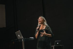 Woman with Microphone Speaking on Stage