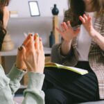 Crop unrecognizable female psychologist and patient discussing mental problems during session